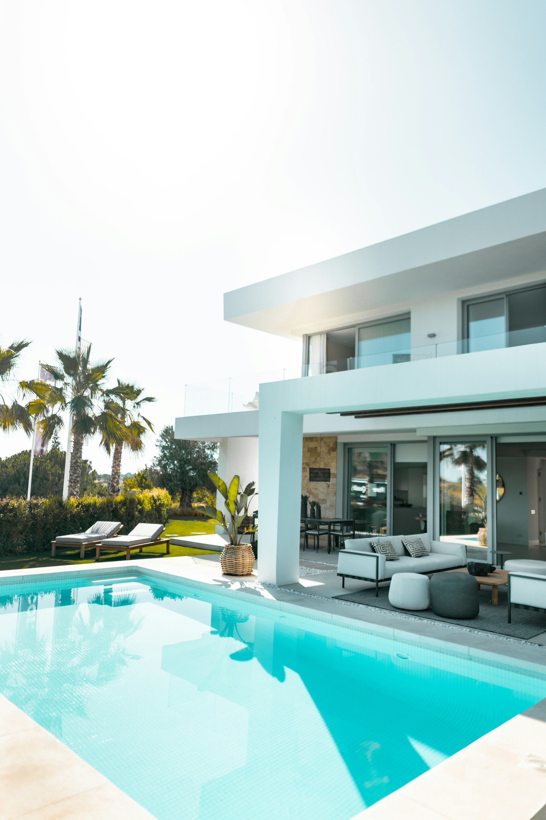 Terrasse et piscine avec mobilier de jardin, palmiers en arrière-plan